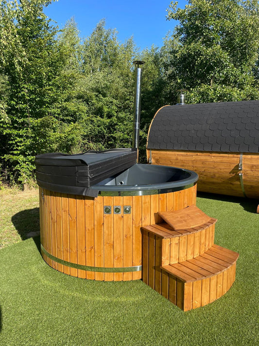 Runder Hot Tub mit heller Holzverkleidung, grauem Becken und Holztreppe im Garten