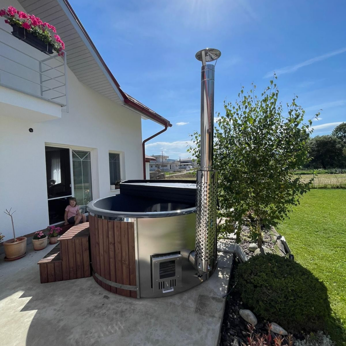 polarsauna shop Hot Tub 200 cm mit Holzverkleidung und integriertem Edelstahl-Ofen auf einer sonnigen Terrasse