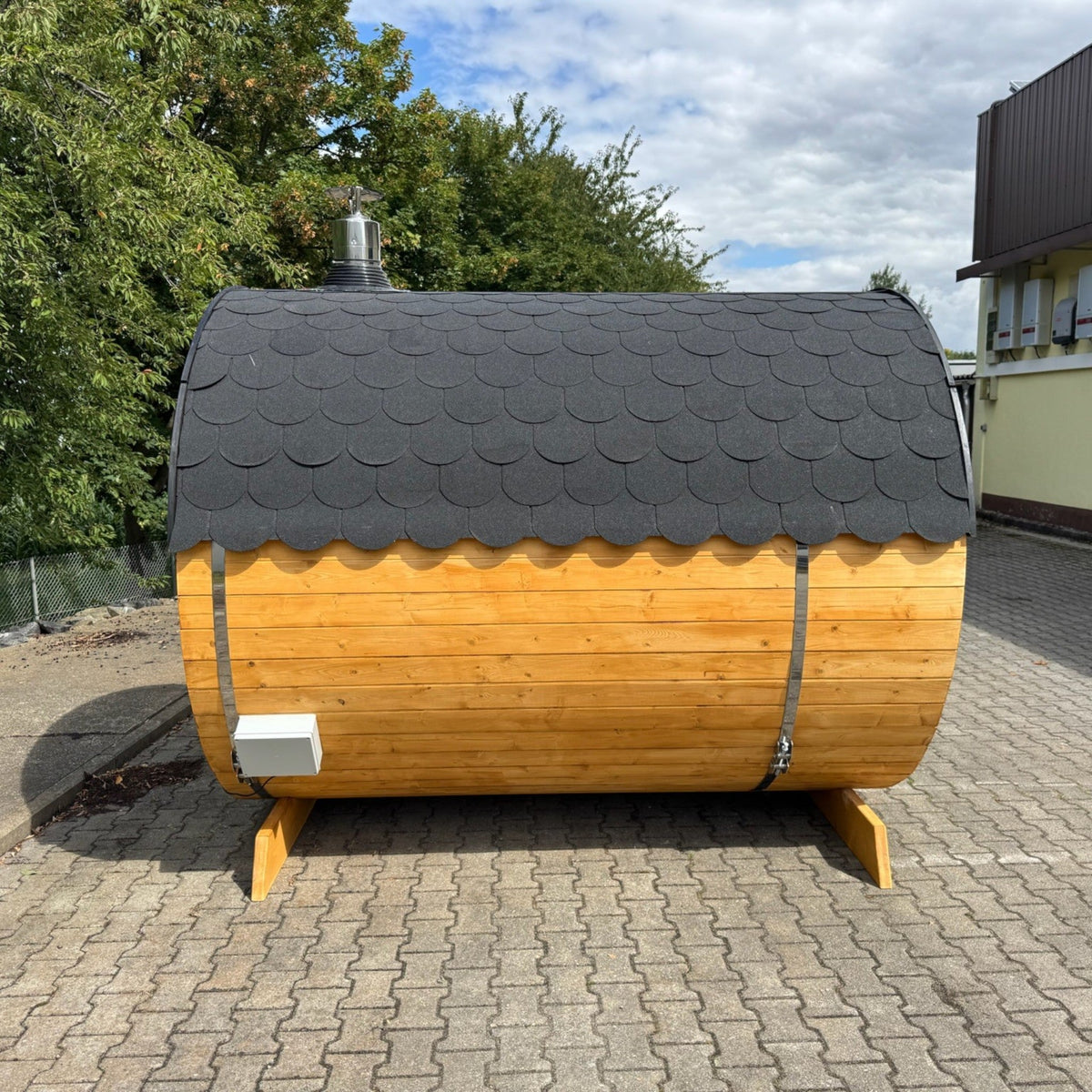 polarsauna shop Fasssauna Trendline aus Fichtenholz mit schwarzem Schindeldach im Außenbereich