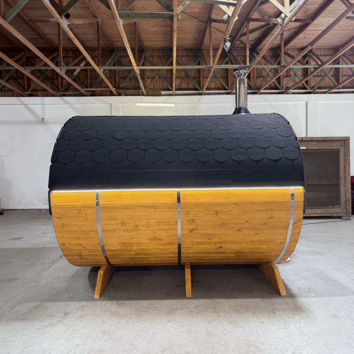 polarsauna shop Fasssauna Highline aus massiver Fichte mit schwarzem Schindeldach und integriertem Holzofen