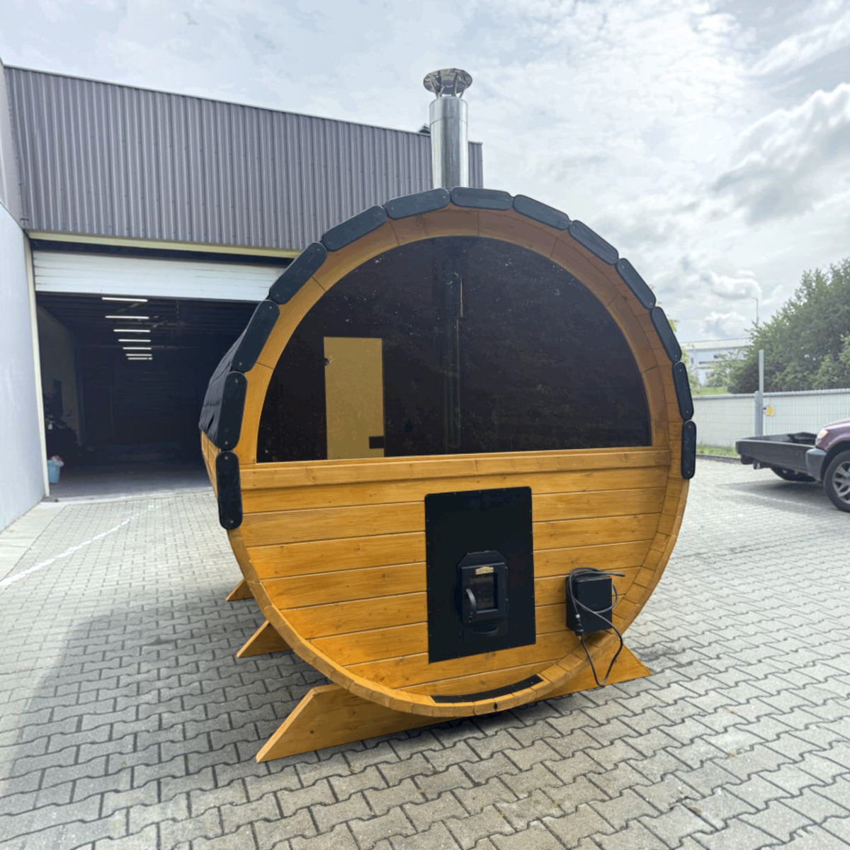 polarsauna shop Fasssauna Highline aus Fichte mit Holzofen und Panorama-Glasfront im Garten