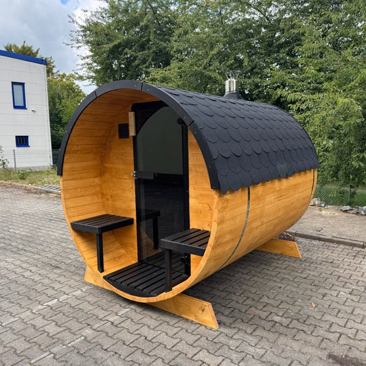 polarsauna shop Fasssauna Trendline aus Fichtenholz mit schwarzem Dach und Glaseingang im Außenbereich