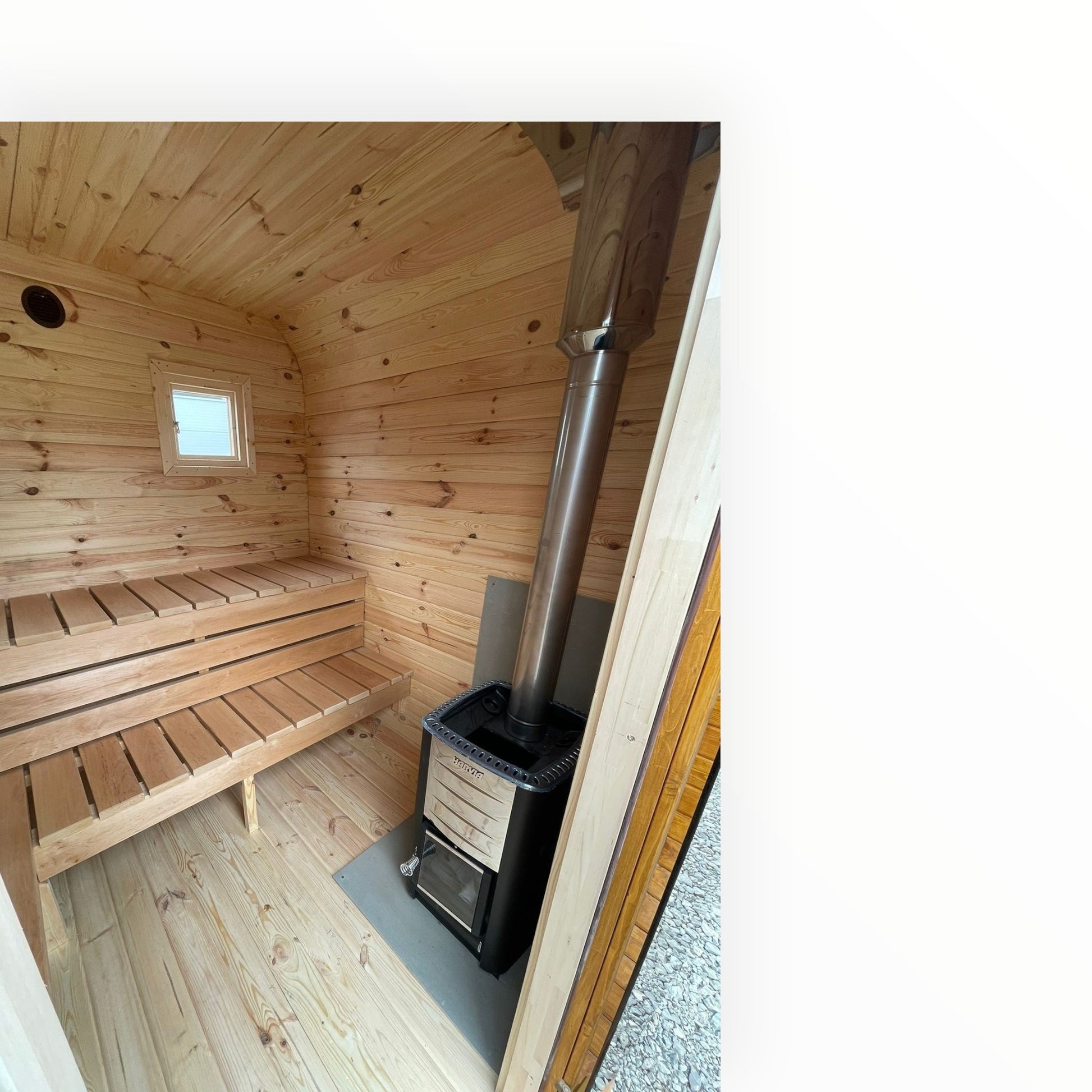 Innenansicht einer polarsauna shop Gartensauna mit hellem Holz, ergonomischen Bänken und einem Harvia Saunaofen
