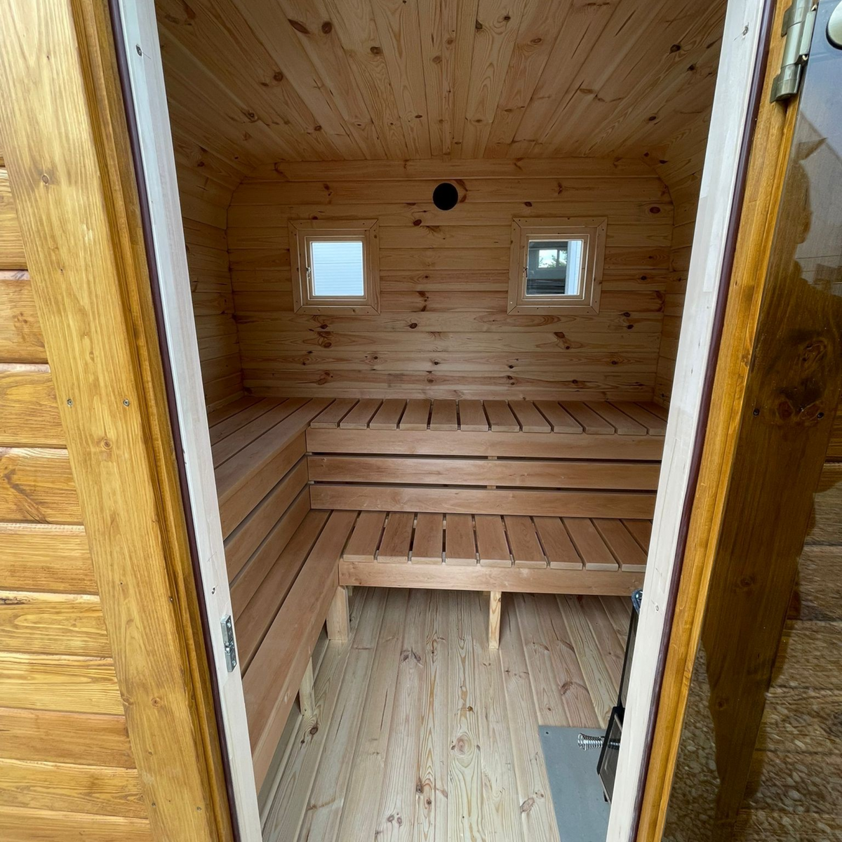 Innenansicht der polarsauna shop Quadro-Sauna 2M mit hellen Fichtenholzbänken und zwei kleinen Fenstern