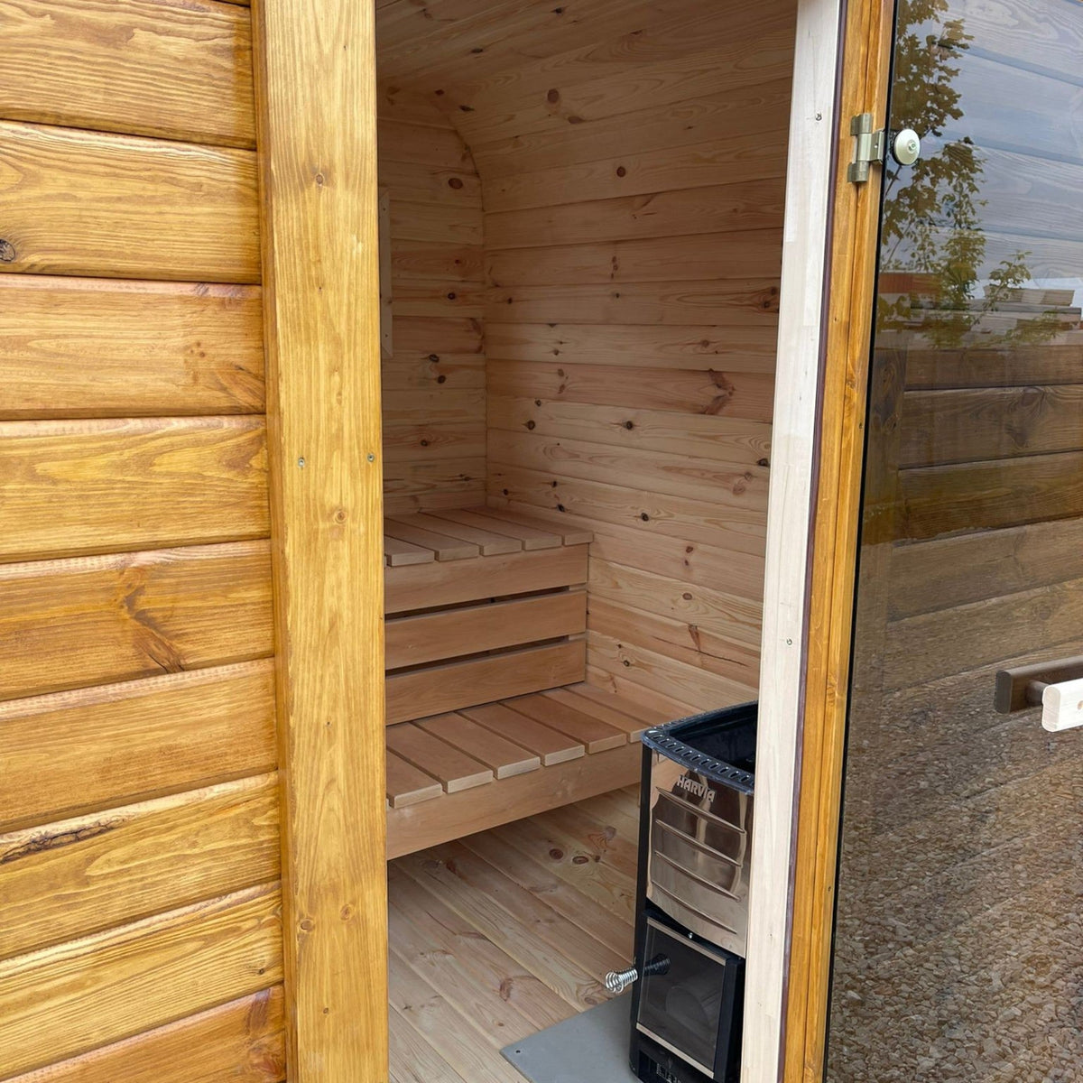 polarsauna shop Quadro-Sauna 2M aus Fichtenholz mit Harvia Ofen, Sitzbänken und getönter Glastür im Innenraum